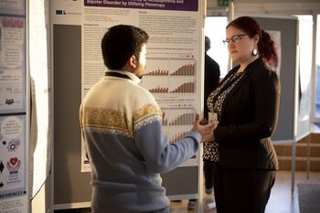 Two Scientia Fellows in a discussion in front of the scientific posters.