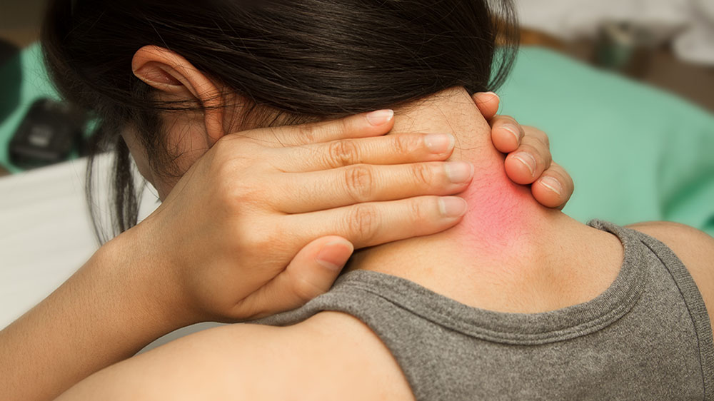 Woman touching her neck which is red with pain