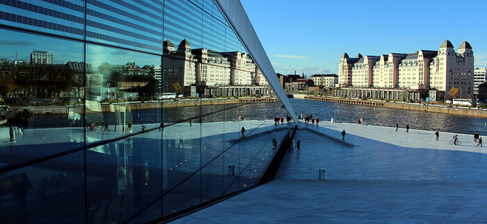 Operataket i Oslo, byen speiler seg i refleksjonen fra operabygget. P? h?gre side av bilde er det lagt inn informasjon om EUHEA-konferansen: dato, tid og tema.