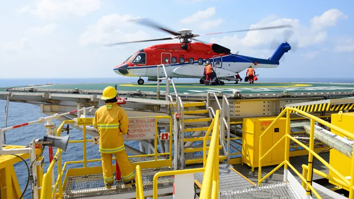 Oil workers boarding a helicopter at an oil rig platform