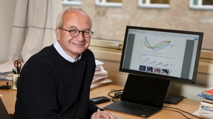 Bildet viser en smilende mann foran en dataskjerm