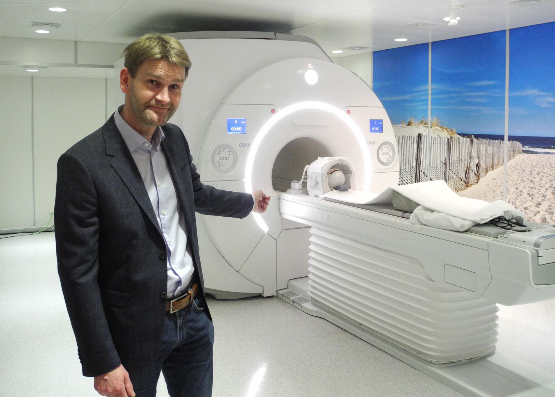 Man points at MRI machine.