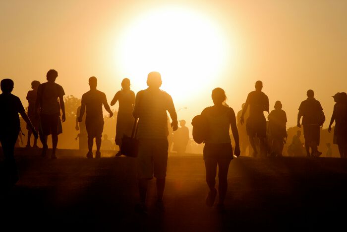 Gruppe av mennesker i sollys. Foto