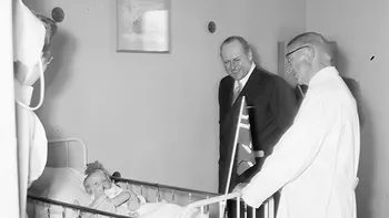 Den nykronede Kong Olav V besøker Rikshospitalets barneklinikk i 1958. Klinikken ble åpnet av Kronprinsesse Märtha i mai 1950. Ukjent fotograf, Universitetets fototekniske avdeling, Rikshospitalet.