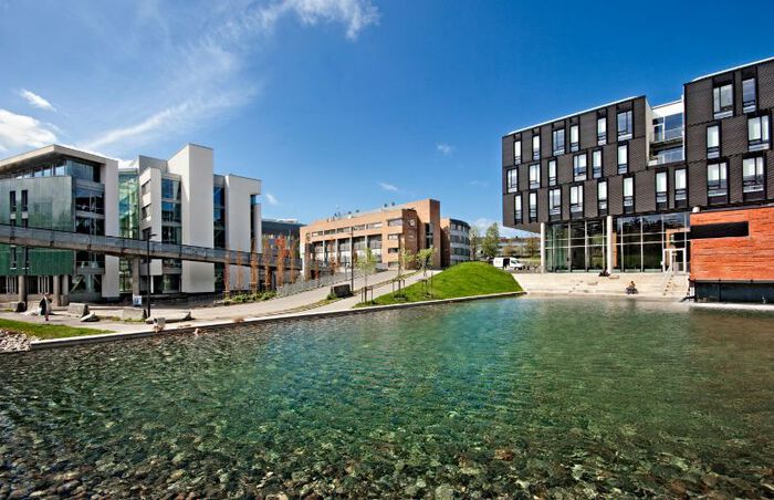 Photo of Oslo Science Park, showing the pond in front of the building on a sunny day