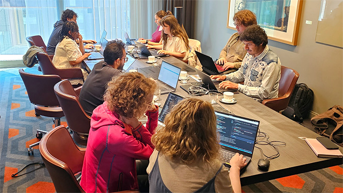 Members of the Mathelier group working on their laptops in a conference room