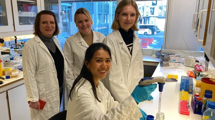 Four women in the lab wearing lab coats