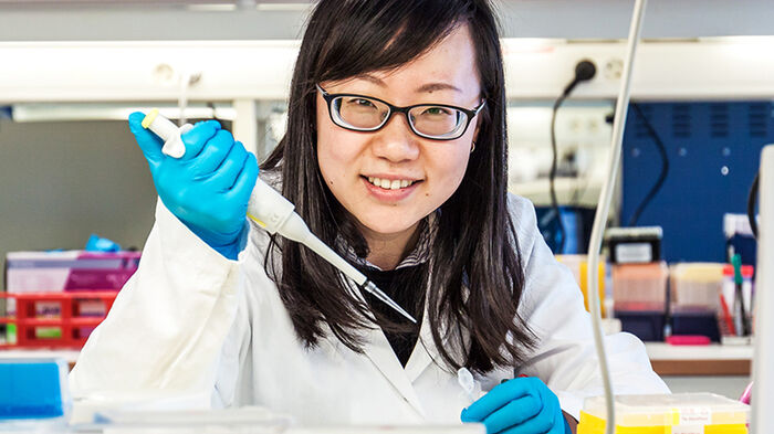 Portrait of Zhuokun in the lab holding a pipette