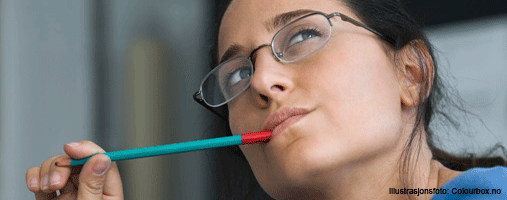 Woman biting on pencil and looking thoughtful